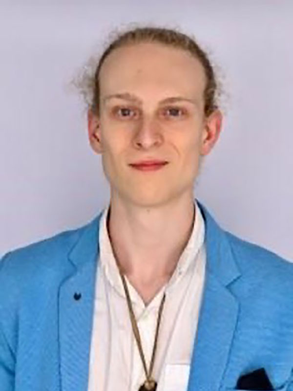 A headshot of Carter Hays, who wears a blue blazer and white shirt.